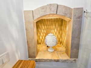a small room with a stone fireplace with a vase at Ddo e Dde dimore nr 56 in Alberobello