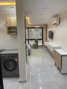 a kitchen with a washing machine in a room at Tokyo in Akouda