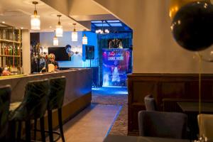 a bar in a restaurant with a stage in the background at Lyons Woodlands Hall in Ruthin