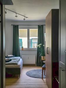 - une chambre avec un lit et une fenêtre avec des rideaux verts dans l'établissement Ausseer AusZeit - beim Meranplatz, à Bad Aussee