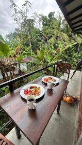 a wooden table with two plates of food on it at Surfside Paddy Villa in Babarenda Central