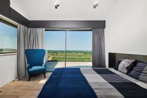 a bedroom with a bed and a chair and a window at Villa Zora in Markovac +18 photos