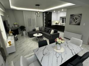 a living room with a couch and a table with flowers at Elysian Escapes in Epanomi