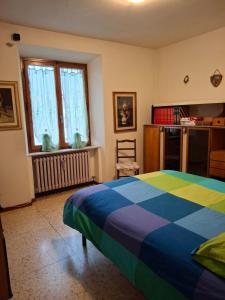 a bedroom with a colorful bed and a window at Casotti in Cutigliano