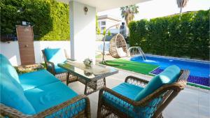 a patio with chairs and a table next to a swimming pool at Çamyuva Lüks Villa in Agva