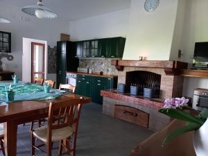 a kitchen with a table and a fireplace at Colle del Sole - Ritiro di Natura e Benessere tra le Colline del Prosecco in Miane