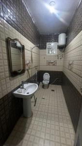 a bathroom with a sink and a toilet at شقق الخيول البرونزية للشقق المخدومة in Şabyā