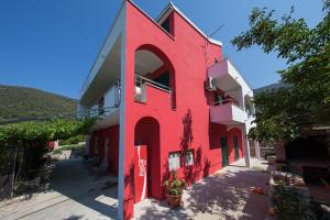 a red building with a large letter on the side at Ground floor apartment in Razvala +6 photos