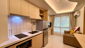 a kitchen with a refrigerator and a counter top at Fantasea Kamala Beach 1 BR 313 in Kamala Beach