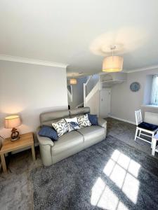 a living room with a couch and a table at Rose Wynd Cottage-Close to beach in Crail