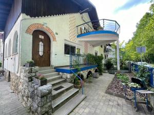 a house with a balcony and stairs in front of it at At the Burkulis' in Ljubljana