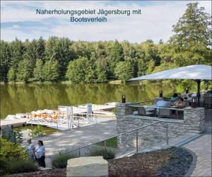 a dock with a table and people standing near a lake at Zentrum der Ruhe - Appartment in Waldmohr