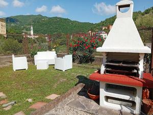 a grill in a garden with flowers in the background at I Mosaici Guesthouse in Ronco Scrivia