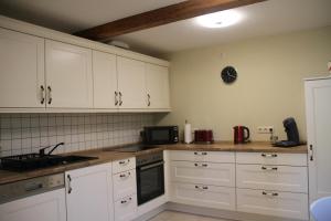a kitchen with white cabinets and white appliances at Ferienhaus Pauline am Glan in Medard