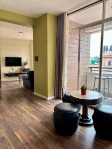 a living room with a table and chairs and a large window at Lavish Stay at Boudha, Kathmandu, Heuju Residence in Kathmandu