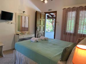 a bedroom with a bed with two pillows on it at Maniatis Garden in Achladies