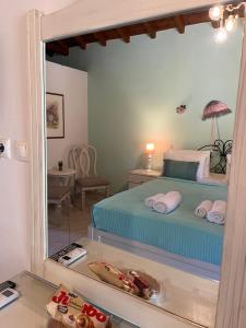 a bedroom with a bed and a mirror at Maniatis Garden in Achladies