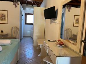 a room with a bed and a desk and a mirror at Maniatis Garden in Achladies