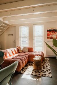 a living room with a large couch and chairs at Slapen aan Zee in Vlissingen