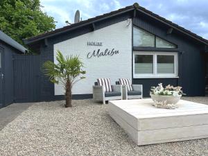 a house with two chairs and a table in front of it at Ferienwohnung MALIBU S am See in Wettringen