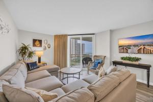 a living room with a couch and a fireplace at Oceanfront Condo Huge Pools Top Rated Ocean Creek Resort in Myrtle Beach