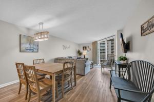 a dining room and living room with a table and chairs at Oceanfront Condo Huge Pools Top Rated Ocean Creek Resort in Myrtle Beach