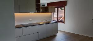 a kitchen with white cabinets and a sink and a window at Big & charming loft with wonderful views in Gavere