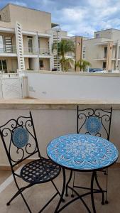 een tafel en twee stoelen op een balkon bij Casa PERLAMARE in Otranto