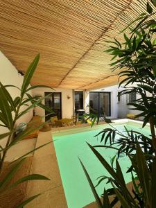 a swimming pool in a house with a wooden ceiling at Villa de l'Ange en Provence in Eyragues