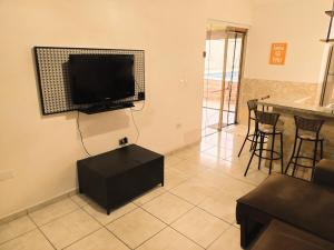 un soggiorno con TV a schermo piatto a parete di Casa com piscina privativa a Bertioga