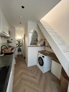a kitchen with a washing machine under a staircase at Tiny House in center Aalsmeer I Close to Schiphol & Amsterdam in Aalsmeer