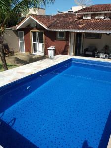 una piscina blu davanti a una casa di Casa com piscina privativa a Bertioga