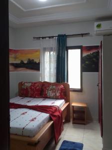 a bedroom with a bed and a window at Résidence Yavanie in Kribi