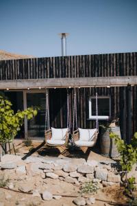 two swinging chairs in front of a building at הפטריוטית-יקב ננה in Mitzpe Ramon +21 photos