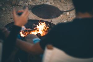 a person sitting in front of a fire at הפטריוטית-יקב ננה in Mitzpe Ramon