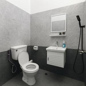 ein Badezimmer mit Toilette, Waschbecken und Spiegel in der Unterkunft 4BR Near SPICE Arena Free Parking in Bayan Lepas