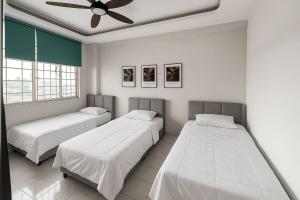 ein Schlafzimmer mit zwei Betten und einem Deckenventilator in der Unterkunft 4BR Near SPICE Arena Free Parking in Bayan Lepas