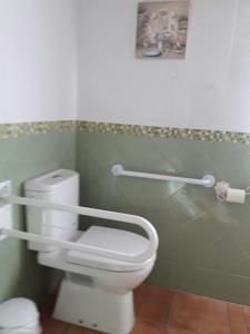 a bathroom with a white toilet and a picture on the wall at Casa Rural la Almazara in Urda