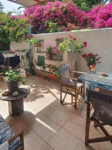 a patio with a table and chairs and flowers at Peace&love-sea studio in Poros