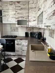 a kitchen with a sink and a stove at Maros Apartman in Makó