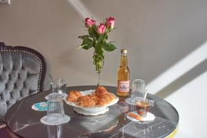 a table with a bottle of wine and a bowl of croissants at Le Boudoir in Troyes +58 photos