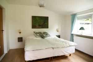a bedroom with a bed and a painting on the wall at Udsen House in Havndal