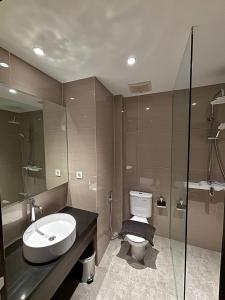 a bathroom with a sink and a toilet at Grand Aurel Hotel Morowali in Epe