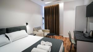 a hotel room with a bed and a desk at Hotel LUMINOSA in Shkodër