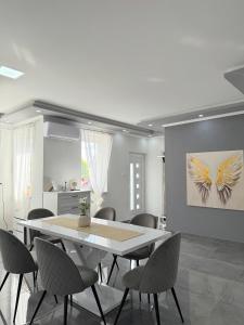 a dining room with a white table and chairs at Aranyszárny Apartman in Gyula