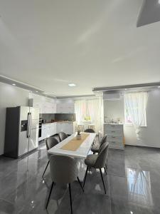 a kitchen with a table and chairs and a refrigerator at Aranyszárny Apartman in Gyula