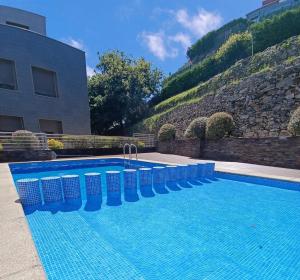 a swimming pool in front of a building at Ático Chill-Out de lujo con piscina y garaje gratis in Vigo +15 photos