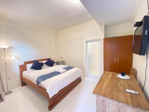 a bedroom with a bed and a television in it at Cozy room Kuta - 1 minutes to the beach by Micky Studio2 in Legian