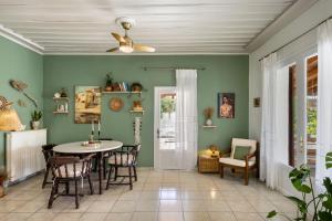 a dining room with green walls and a table and chairs at Mira Seaside Residence in Kalívia Thorikoú