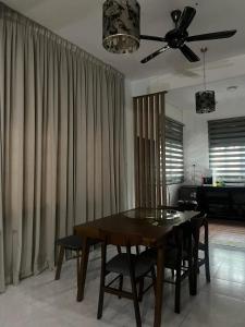 a dining room table with chairs and a ceiling fan at MIA guests house in Nilai
